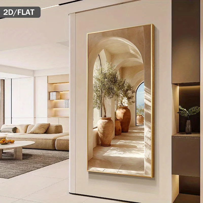 A tall rectangular wall mirror with a thin gold frame hangs on a white wall in a modern interior. The mirror reflects an arched corridor with large terracotta vases and plants.