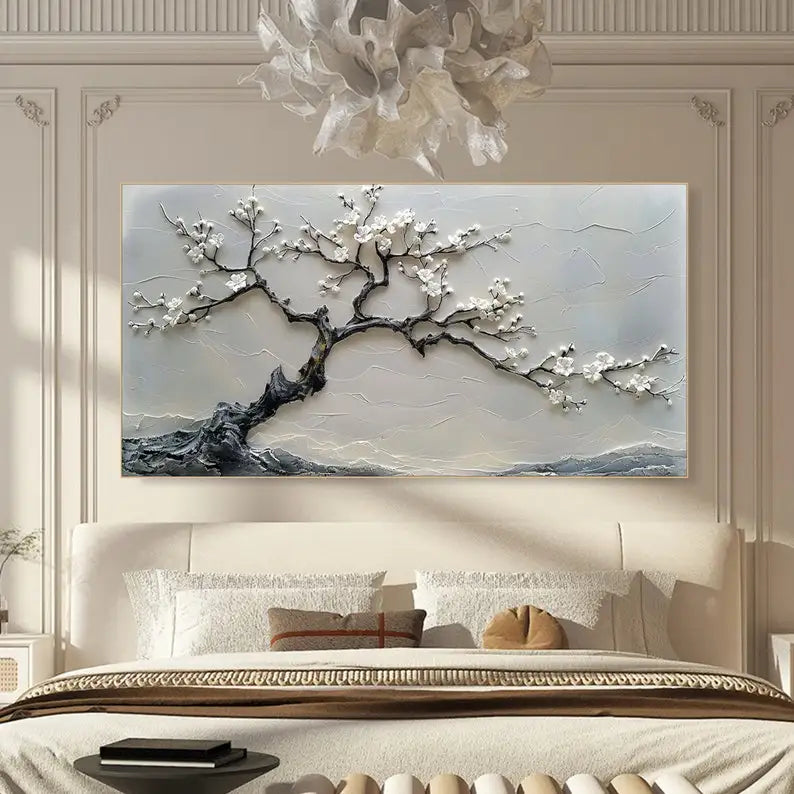 Decorative wall art of a tree with white flowers in a bedroom setting.