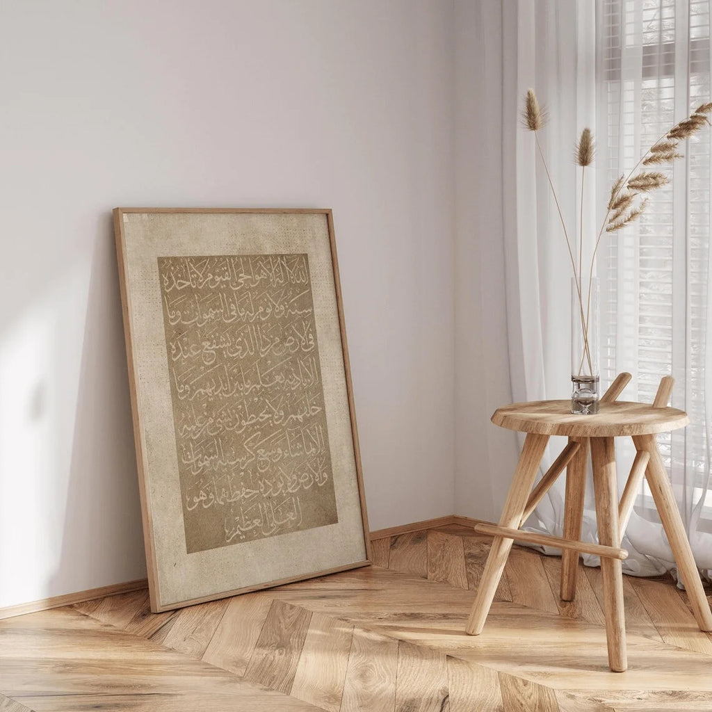 Framed artwork on a wall next to a wooden side table with a vase.