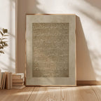 Framed artwork with Arabic calligraphy on a wooden floor with books and a plant.