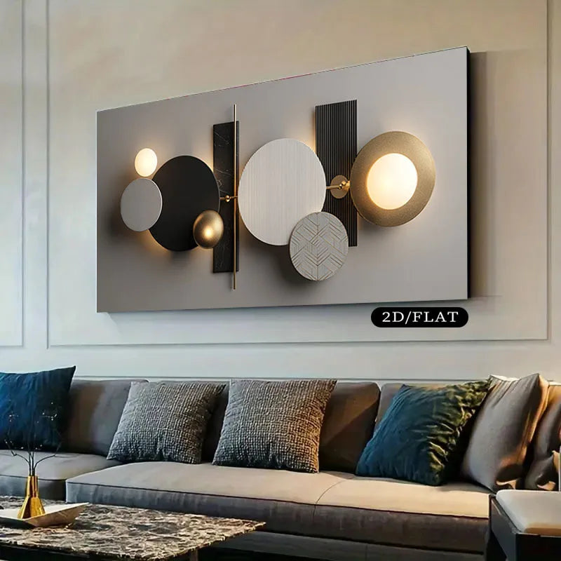 A modern abstract wall art piece mounted above a sofa in a living room. The artwork features overlapping circles, rectangles, and illuminated light bulbs in black, white, beige, and gold tones.