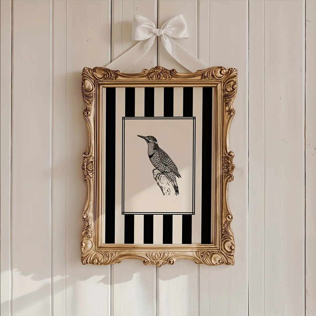 Decorative framed picture with a bird illustration on a striped background, hanging on a wooden wall.