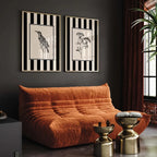Orange sofa in a room with black and white striped wall art and gold side tables.