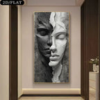 A vertical wall art print showing a split human face in black, gray, and white sculptural style, displayed on a beige wall in a modern interior hallway. The product itself is the artwork, and the surrounding room is visible as context.