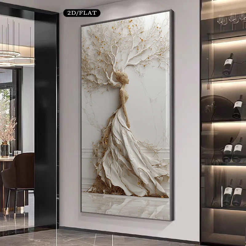 A large vertical framed wall art piece hangs on a light gray wall in a modern interior. The artwork depicts a stylized tree with white and beige branches and trunk, accented with small gold leaf-like details.