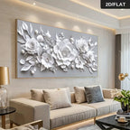 Large rectangular wall art featuring a 3D-effect white floral design with layered roses, leaves, and buds on a light gray background, displayed above a beige sofa in a modern living room. A small '2D/FLAT' label appears in the top-right corner.