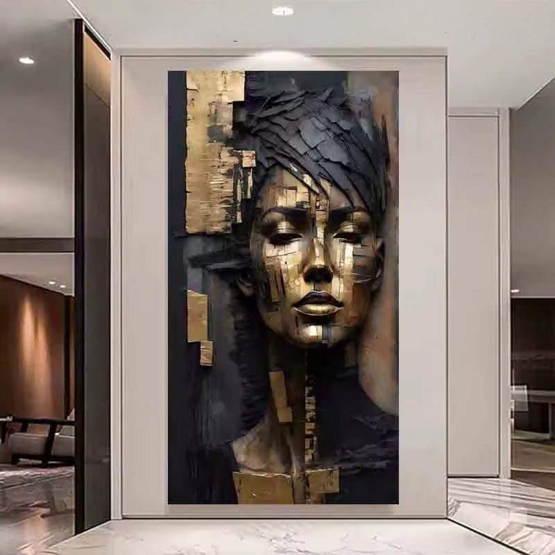 A large wall art piece featuring a stylized female face in metallic gold and dark charcoal tones, displayed in a modern interior hallway with marble flooring and glass walls.