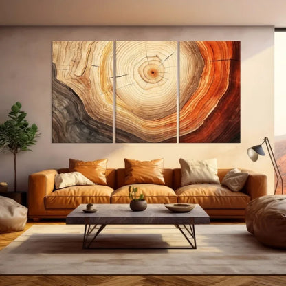 A three-panel canvas wall art set depicting a detailed wood grain or tree trunk cross-section pattern in warm tones, displayed above a tan leather sofa in a modern living room setting.