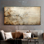 A large rectangular wall art piece featuring a beige and brown abstract branch and leaf design, displayed above a gray sofa with neutral-toned pillows in a styled living room setting.