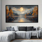 A large landscape art print hangs on a light gray wall above a modern sectional sofa. The artwork depicts a moonlit mountain lake scene with golden autumn trees, dark pine forests, snow-capped peaks, and a glowing full moon reflected in the water.