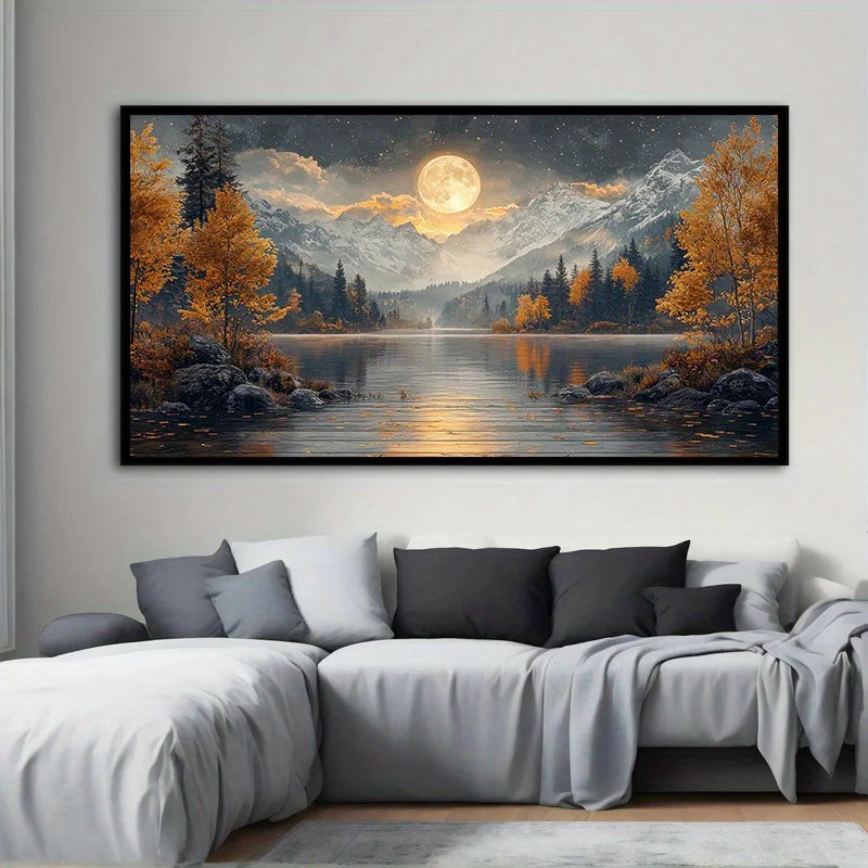A large landscape art print hangs on a light gray wall above a modern sectional sofa. The artwork depicts a moonlit mountain lake scene with golden autumn trees, dark pine forests, snow-capped peaks, and a glowing full moon reflected in the water.