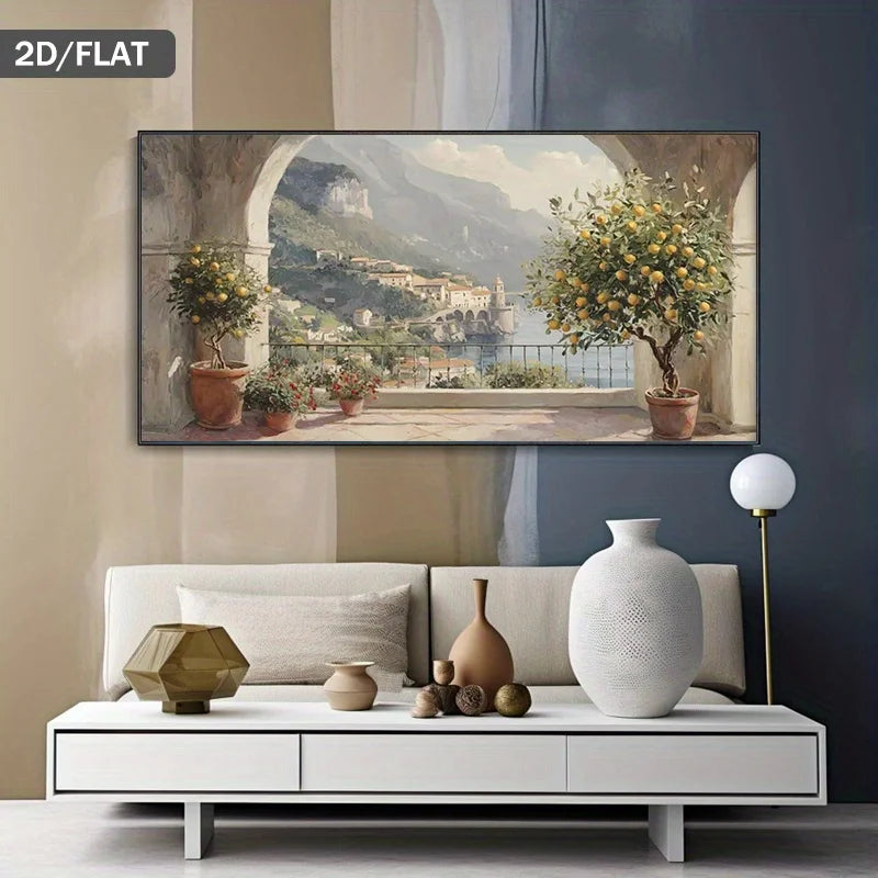A horizontal canvas print depicting a scenic Italian coastal town with lemon trees and mountains, displayed on a wall above a modern white sofa in a styled living room.