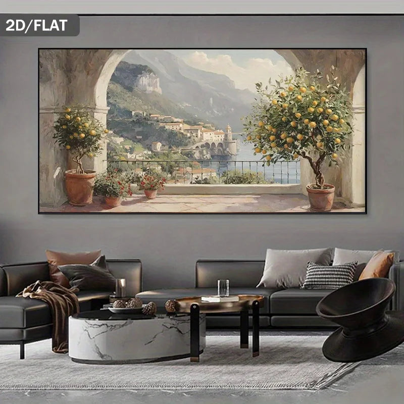 A large wall art print showing a scenic coastal town with mountains, water, and lemon trees, displayed above a modern gray sofa in a styled living room. The print has a dark gray border and the words '2D/FLAT' appear in the top-left corner.