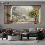 A large wall art print showing a scenic coastal town with mountains, water, and lemon trees, displayed above a modern gray sofa in a styled living room. The print has a dark gray border and the words '2D/FLAT' appear in the top-left corner.
