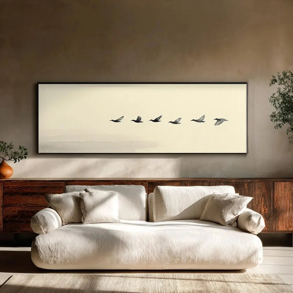 Beige sofa in a room with a framed artwork of birds on a beige wall.