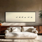 Beige sofa in a room with a framed artwork of birds on a beige wall.