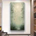 A vertical canvas wall art print depicting a misty forest path with tall trees, flying birds, and a glowing moon, displayed on a white wall in a modern interior setting.