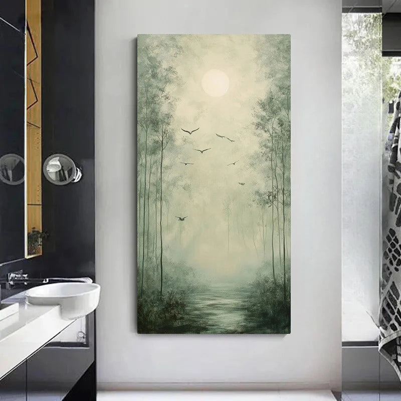 A vertical canvas wall art print depicting a misty forest path with tall trees, flying birds, and a glowing sun, displayed on a light gray wall in a modern bathroom setting.