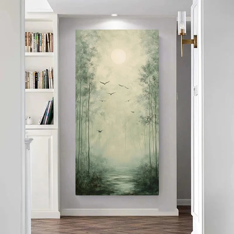 A vertical canvas wall art print depicting a misty bamboo forest with a glowing sun and birds, displayed on a light gray wall in a modern hallway with a bookshelf on the left.