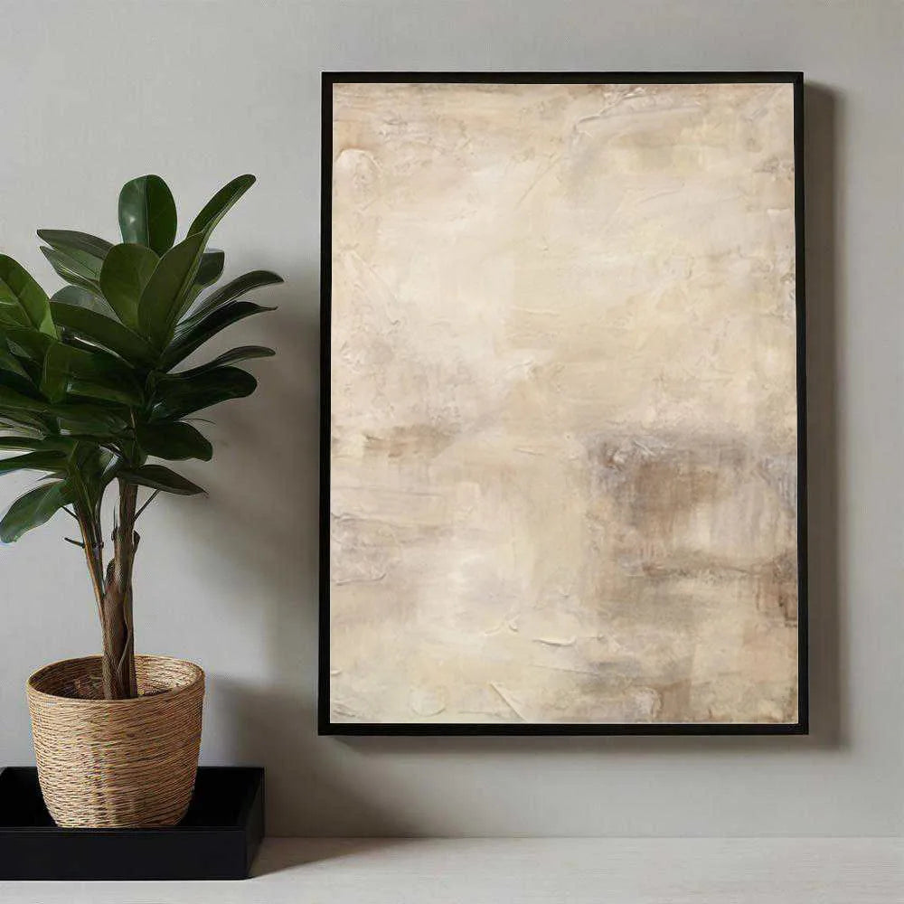 Abstract art print in a black frame on a wall next to a potted plant.