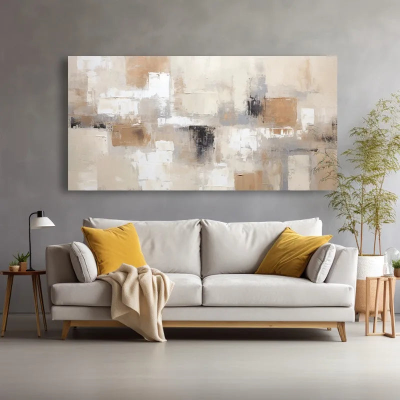 A large rectangular abstract canvas print in beige, white, brown, and black hangs on a gray wall above a light gray sofa with yellow accent pillows and a beige throw blanket in a modern living room setting.