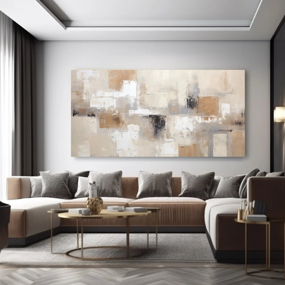 A large rectangular abstract canvas print with beige, cream, brown, and gray tones hangs on a light gray wall above a modern sectional sofa in a styled living room.