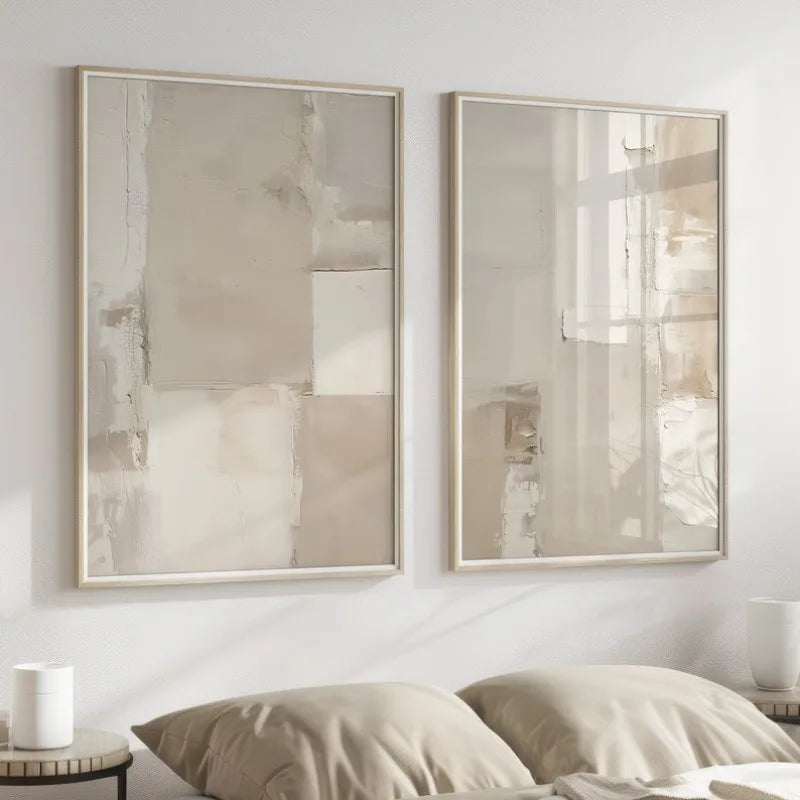 Two framed abstract paintings on a wall above a bed.