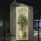 A wall art print showing a potted olive tree with green leaves and gold olives, mounted on a beige wall in a modern interior space. The print has an ornate cream and gold border with a central arch design.