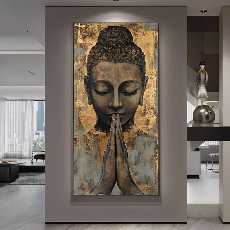 A large vertical wall art piece featuring a serene Buddha head with hands in prayer pose, shown hanging on a gray wall in a modern interior hallway.