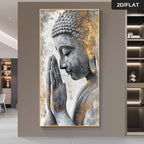 A large vertical framed wall art print showing a gray Buddha bust with gold leaf-like texture accents, displayed on a taupe wall in a modern interior. A black corner label reads “2D/FLAT.