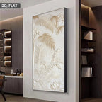A large vertical framed wall art piece with a raised tropical leaf pattern in warm cream and beige tones, displayed on a light wall in a modern interior setting.