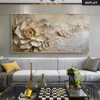 A large rectangular wall art piece with a 3D floral design, featuring a prominent beige peony flower and textured gold leaf details, displayed in a modern living room setting above a gray sofa.