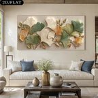 A large rectangular wall art piece featuring a 3D relief design of ginkgo leaves in shades of green, beige, and gold, displayed above a modern white sofa in a styled living room.