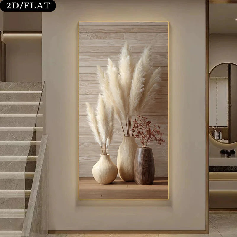 A framed wall art print displayed in a modern interior hallway. The artwork shows three beige and brown ceramic vases filled with tall cream pampas grass and small dried red stems, set against a light wood plank background with a thin gold frame.